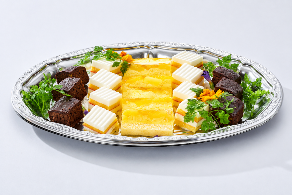 オードブルプランに含まれるケーキアソート。チョコレートケーキや白いケーキ、黄色いケーキを盛り合わせたデザートプレート